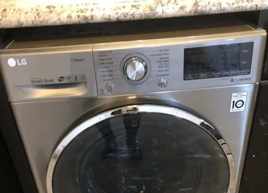 An LG front load washing machine with the door open.