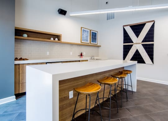 a kitchen with a white counter top and three stools at 7 Pointe Apartments, Indianapolis, IN