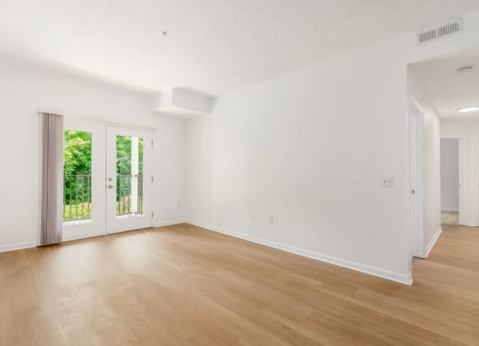 an empty living room with white walls and wood floors
