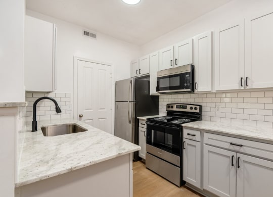 a kitchen with white cabinets and stainless steel appliances
