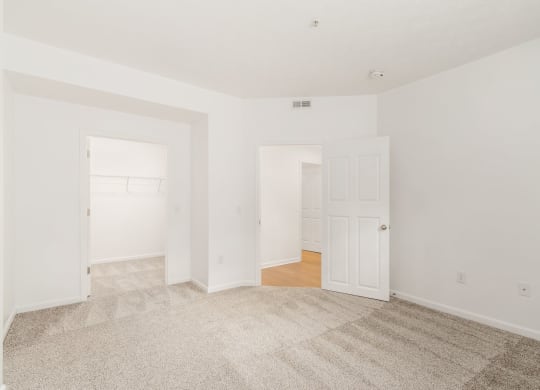 an empty living room with white walls and a carpet