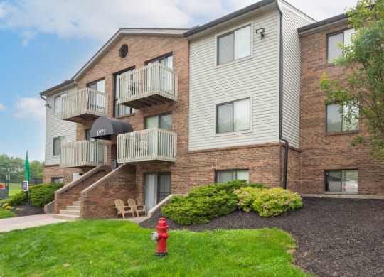 a red fire hydrant in front of a brick apartment building at The Woodridge Collection, Fairfield, OH 45014