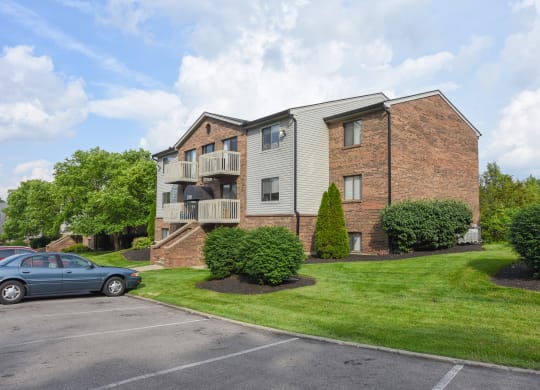 an apartment building with a parking lot and grass at The Woodridge Collection, Ohio, 45014