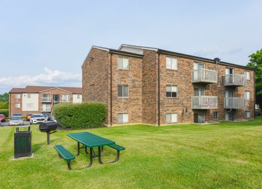 a green picnic table in front of an apartment building at The Woodridge Collection, Fairfield