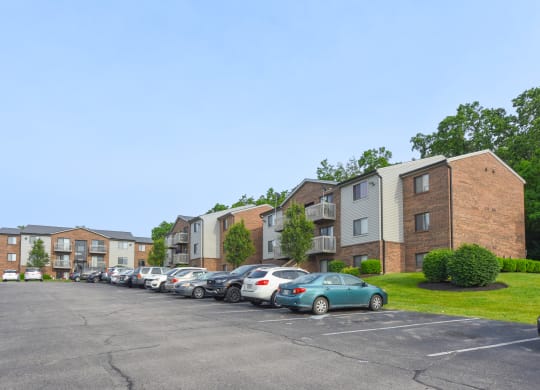 a parking lot with cars parked in front of apartment buildings at The Woodridge Collection, Fairfield, OH 45014