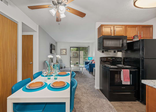 a kitchen and living room with a white table and blue chairs at The Woodridge Collection, Ohio, 45014