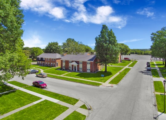 A street view of a residential area with houses and cars.