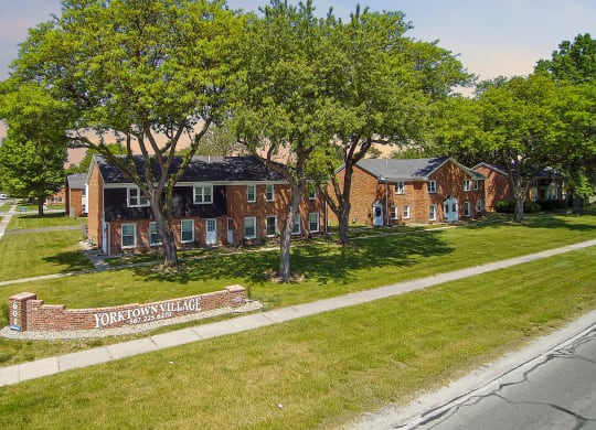 an aerial view of a brick house on the side of a street