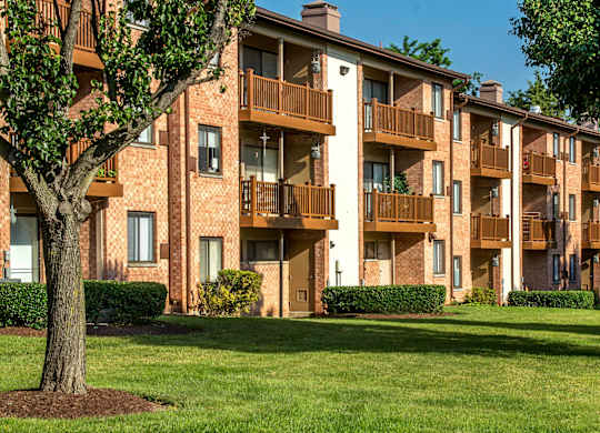 A large apartment complex with a green lawn in front at Rose Hill Apartments, Alexandria