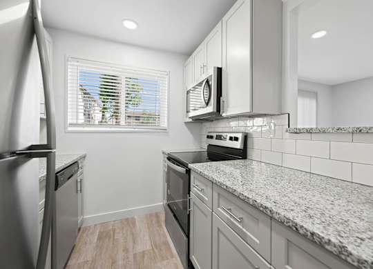 A kitchen with granite countertops and stainless steel appliances at Rose Hill Apartments, Alexandria, 22310
