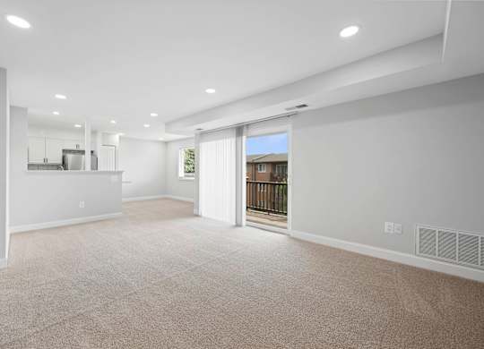 A spacious living room with a sliding glass door leading to a balcony at Rose Hill Apartments, Alexandria, VA, 22310