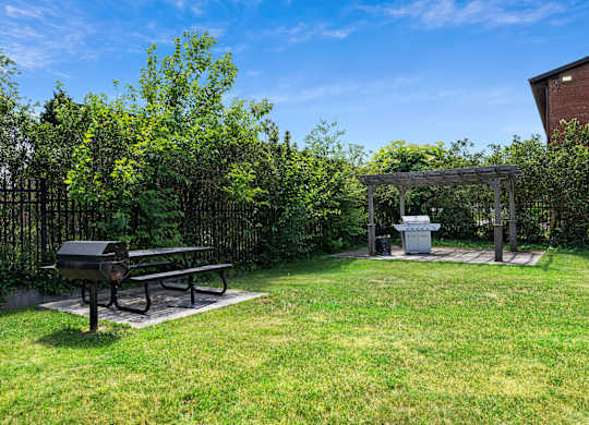 A picnic table is in the middle of a grassy area at Rose Hill Apartments, Virginia