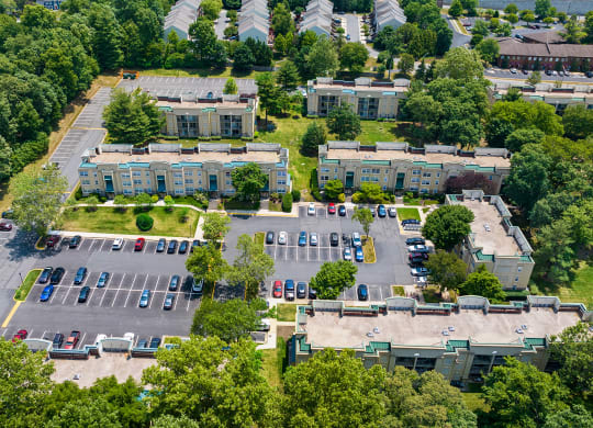 an aerial view of a parking lot with several buildings and trees