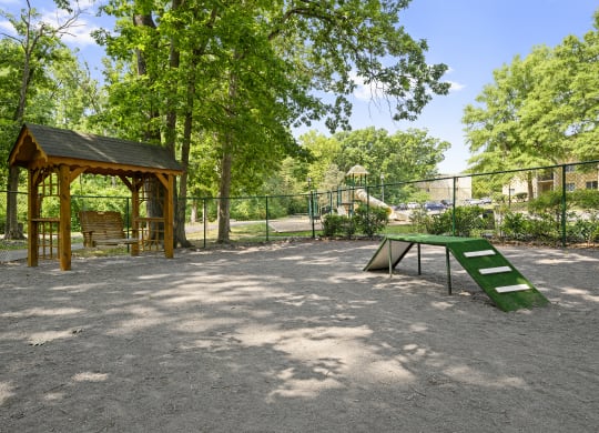 a picnic area with a picnic table and a bench in a park