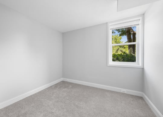 an empty room with white walls and a window