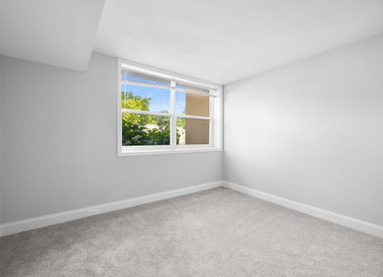 an empty room with white walls and a window