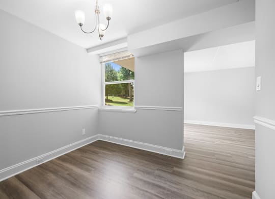 an empty room with white walls and a window
