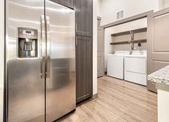 a kitchen with stainless steel appliances and a laundry room