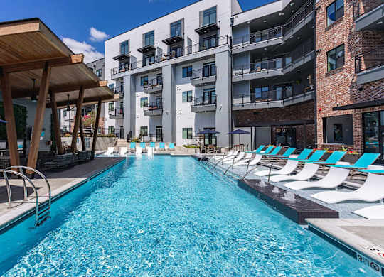 a swimming pool with lounge chairs next to an apartment buildingat Sterling Nashville West Apartments, Nashville, TN