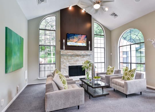Windsor Oak Creek - Clubroom with couches and a coffee table in front of a fireplace in Fairfax VA