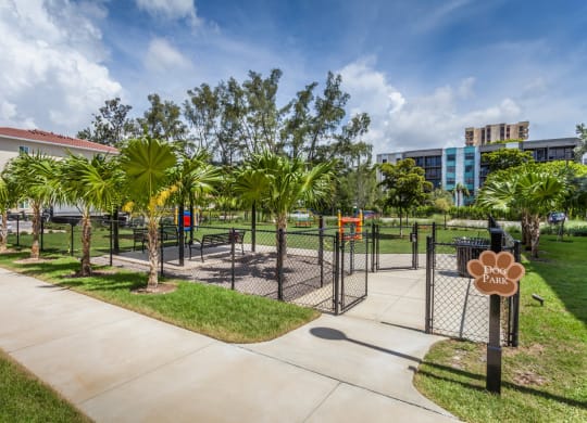 Fenced in dog park with palm trees and buildings at Windsor Biscayne shores in North Miami
