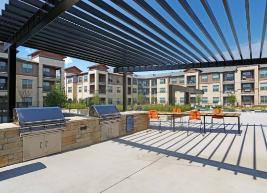 Outdoor patio with barbecue grills at Windsor Lakeyard District, an apartment community in North Dallas