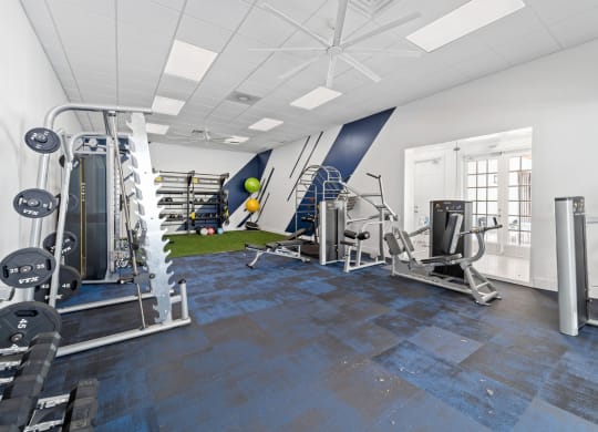 A large fitness room with weights and other exercise equipment at Windsor Coral Springs, Coral Springs, FL