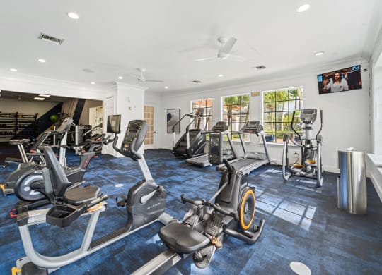 A gym with cardio equipment and a flat screen tv at Windsor Coral Springs, Coral Springs, FL