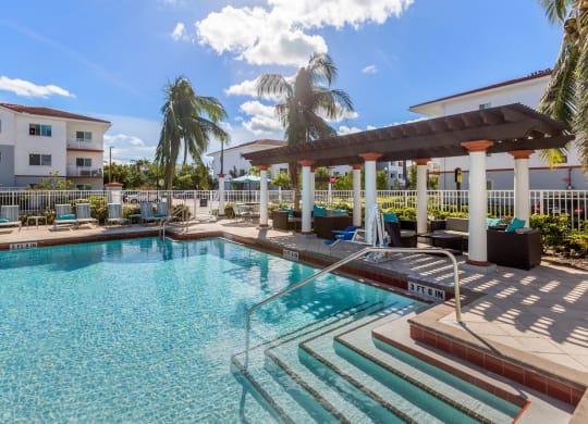 Resort style pool with lounge chairs and a pergola at Windsor Biscayne shores in North Miami