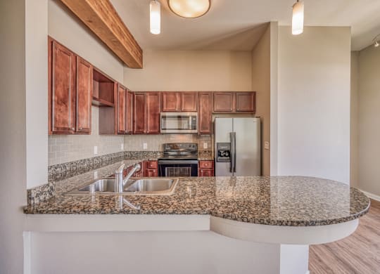 A kitchen with granite countertops and wooden cabinets  at The District, Denver, CO