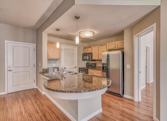 A kitchen with granite countertops and stainless steel appliances at The District, Denver, CO