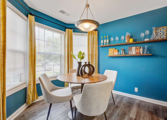 Dining room with blue accent wall and yellow curtains at Windsor Kingstowne, Alexandria, VA 22315