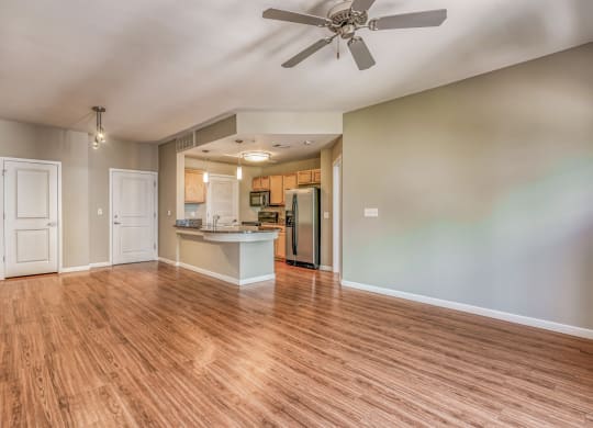 A living and kitchen area with a ceiling fan and hardwood floors at The District, Denver, CO