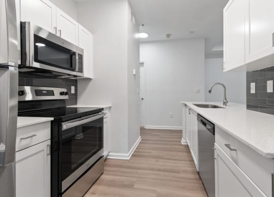 Renovated kitchen with white cabinets and black appliances at Windsor Vinings, Atlanta, GA