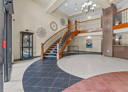 A staircase with a wooden banister and a metal handrail.