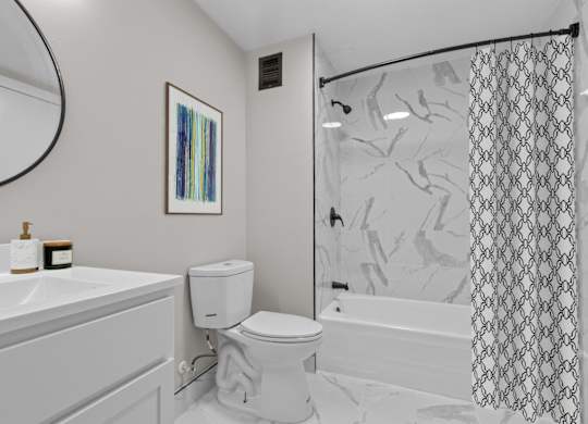 A bathroom with a toilet, sink, and shower.