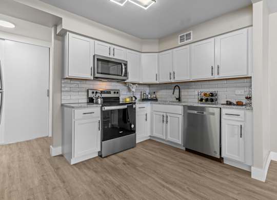A kitchen with white cabinets and stainless steel appliances.