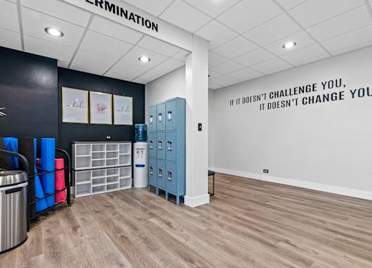 A room with a motivational quote on the wall and a trash bin.