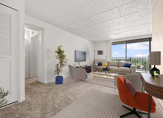 A living room with a white couch, a red chair, and a television.