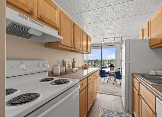 A kitchen with a white stove and wooden cabinets.