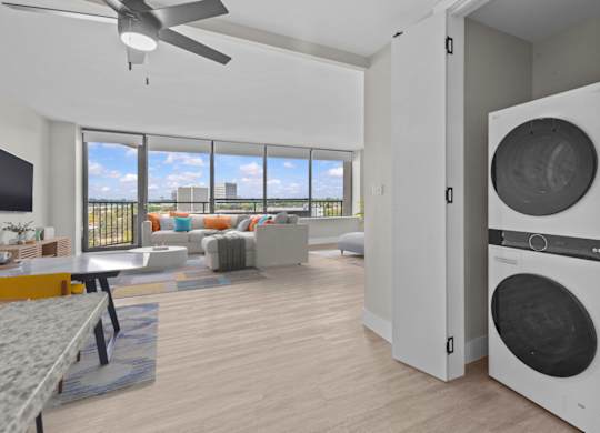 A modern living room with a washing machine built into the wall.