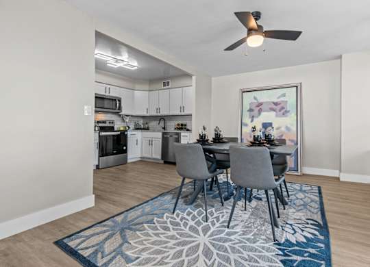 A dining room with a table set for four.