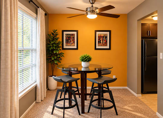 A dining room with a table and chairs.