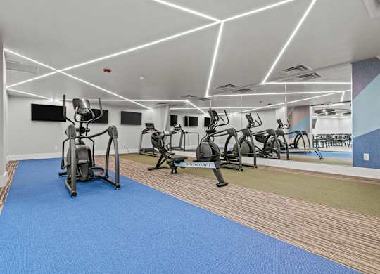 A gym with a blue mat and exercise equipment.