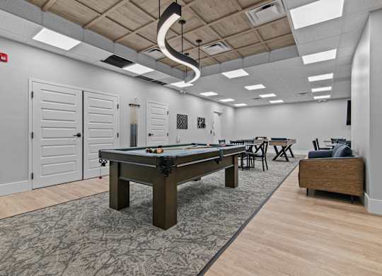 A room with a pool table and a bench.