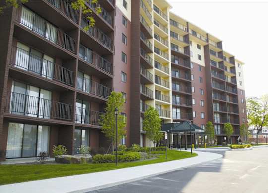 Apartment building with a green tree in front.