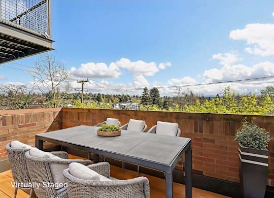 A patio with a table and chairs overlooking a landscape.
