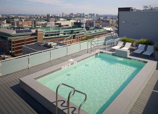 A rooftop pool with a cityscape in the background.