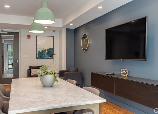 A modern dining room with a marble table and grey chairs.