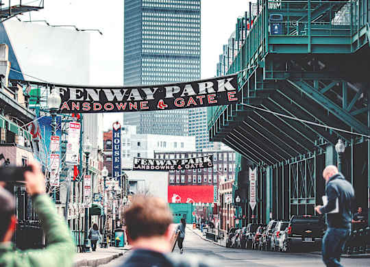 A man is taking a photo of a street with a sign that reads
